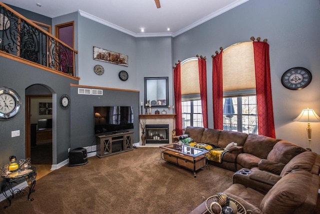 2704 Kettle Ct, West Bend, WI 53090 - living area featuring carpet, a premium fireplace, visible vents, ceiling fan, and arched walkways