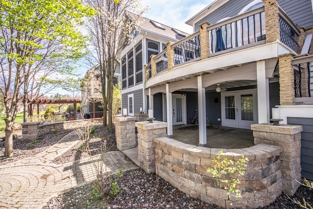 2704 Kettle Ct, West Bend, WI 53090 - back of property featuring a sunroom, a patio area, french doors, and a balcony