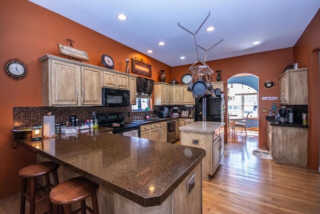 2704 Kettle Ct, West Bend, WI 53090 - kitchen with a peninsula, arched walkways, black appliances, and plenty of natural light