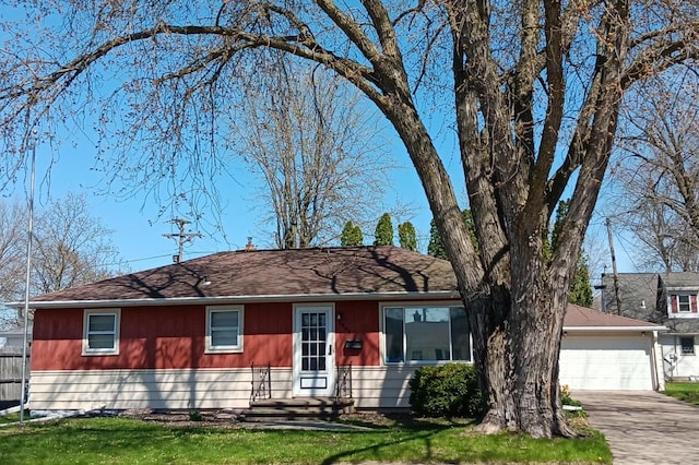 single story home featuring a front yard, concrete driveway, and a garage