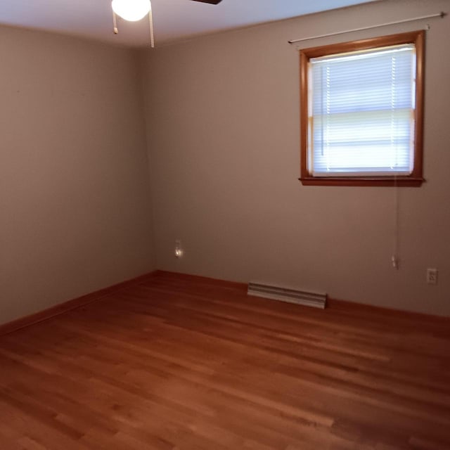 empty room featuring light wood finished floors, visible vents, and ceiling fan