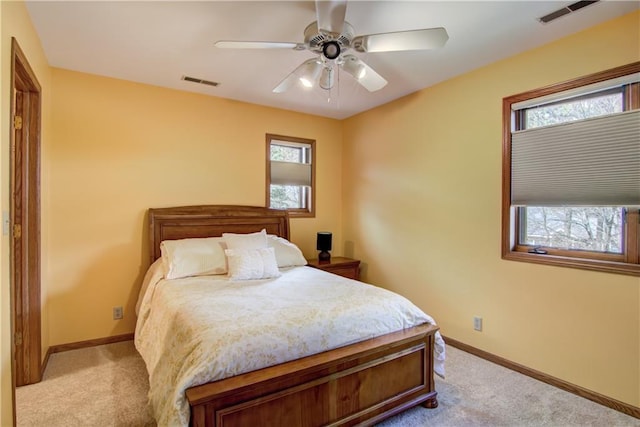 carpeted bedroom with baseboards, multiple windows, and visible vents
