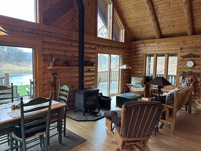 living room with a wood stove, high vaulted ceiling, and plenty of natural light