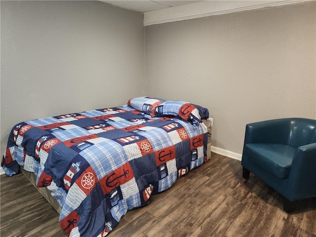 bedroom with baseboards and wood finished floors