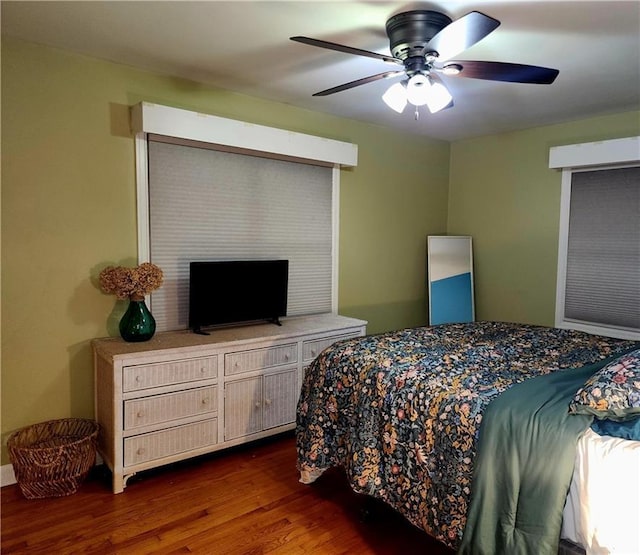bedroom with ceiling fan and dark wood-style floors