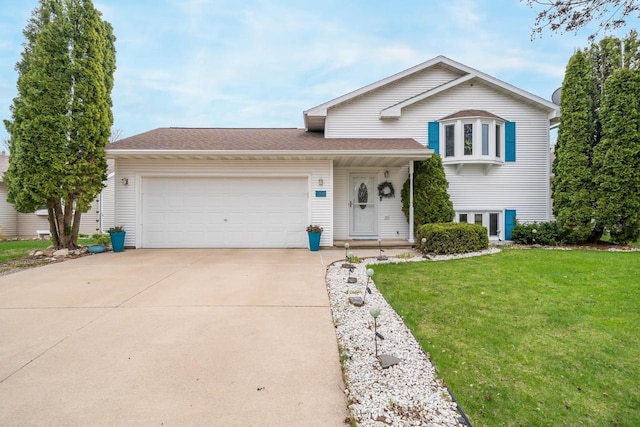 split level home with a front lawn, concrete driveway, and an attached garage