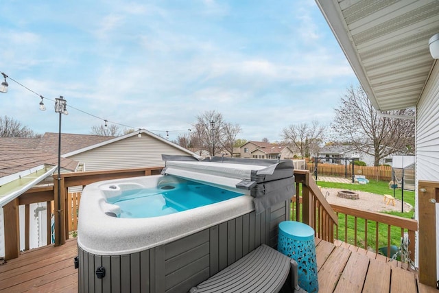 deck with a fire pit, a hot tub, and fence