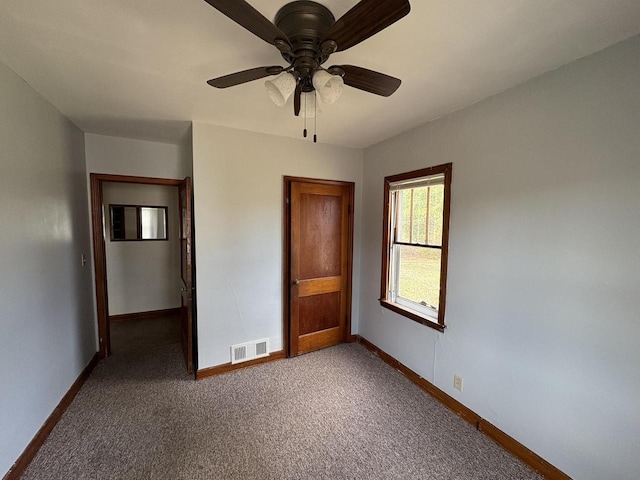 unfurnished bedroom featuring carpet, baseboards, a ceiling fan, and visible vents