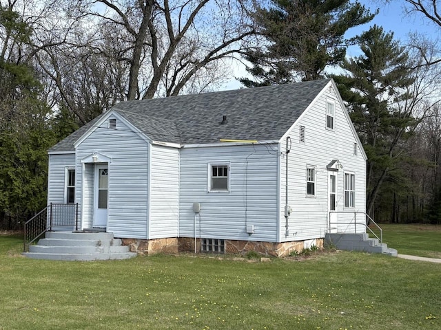view of front facade with a front yard and a shingled roof