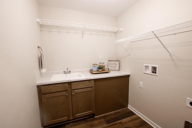 laundry room with hookup for a washing machine, a sink, cabinet space, hookup for an electric dryer, and dark wood-style floors
