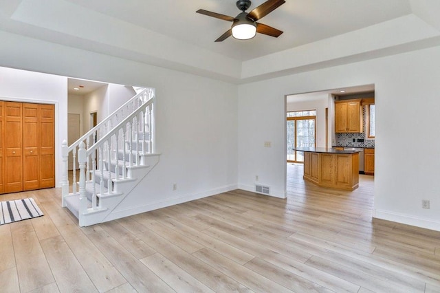 4109 Oak Ter, Weston, WI 54476 - unfurnished living room featuring light wood-style floors, visible vents, a raised ceiling, and ceiling fan