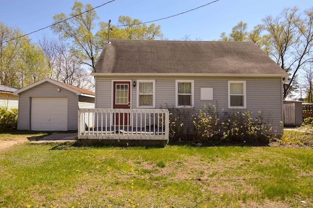 cape cod-style house featuring a garage, a wooden deck, a front lawn, an outdoor structure, and driveway