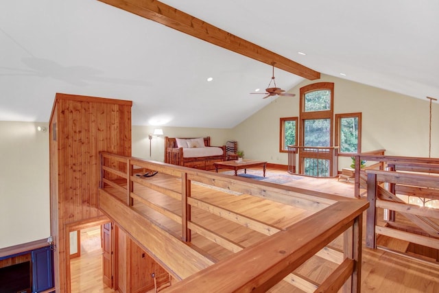 additional living space featuring a ceiling fan, light wood-style flooring, and vaulted ceiling with beams