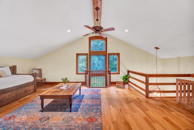 living room with baseboards, wood finished floors, lofted ceiling with beams, and ceiling fan