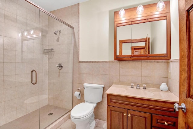 full bath featuring a shower stall, tile walls, vanity, and toilet