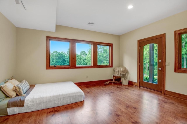 bedroom with wood finished floors, visible vents, baseboards, and recessed lighting