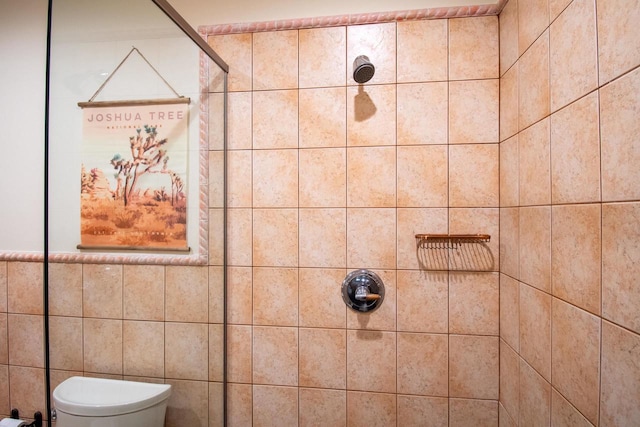 full bathroom featuring a tile shower, tile walls, and toilet
