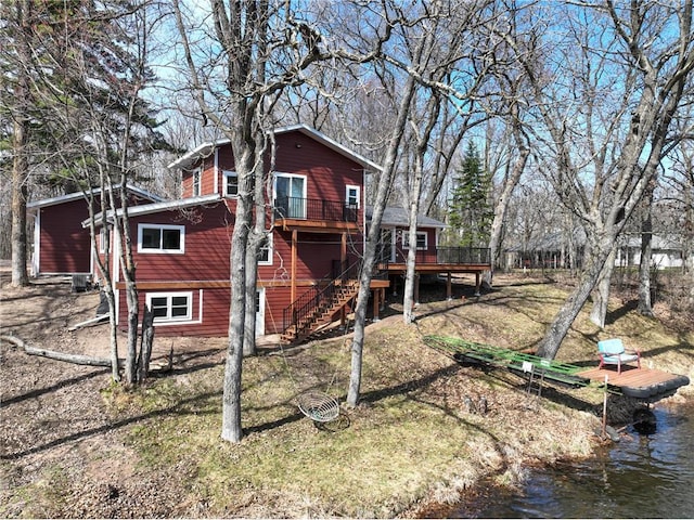 exterior space with a yard, stairway, and a deck with water view