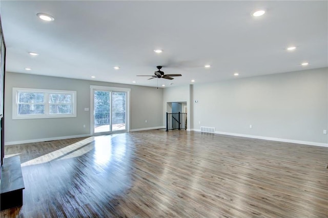 unfurnished living room featuring baseboards, recessed lighting, visible vents, and wood finished floors
