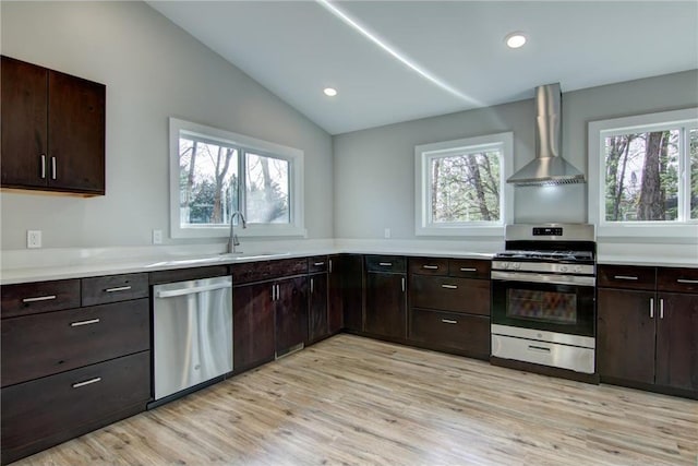 kitchen with vaulted ceiling, wall chimney exhaust hood, plenty of natural light, and appliances with stainless steel finishes