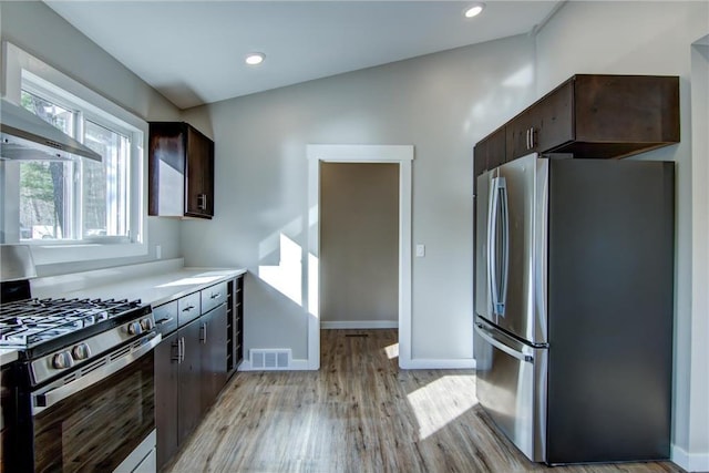 kitchen featuring visible vents, light wood-style flooring, baseboards, dark brown cabinets, and appliances with stainless steel finishes