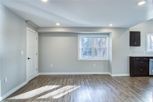 interior space with wood finished floors, baseboards, and a healthy amount of sunlight