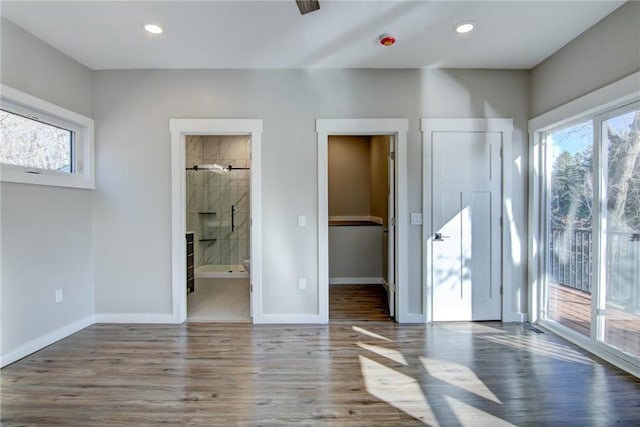 unfurnished bedroom featuring recessed lighting, baseboards, ensuite bath, access to outside, and wood finished floors