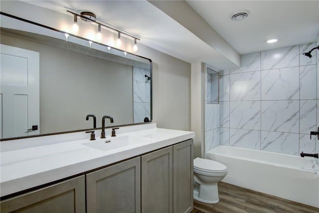 full bath with toilet, wood finished floors, shower / washtub combination, visible vents, and vanity