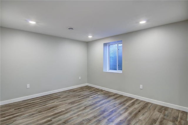 unfurnished room with recessed lighting, baseboards, and wood finished floors