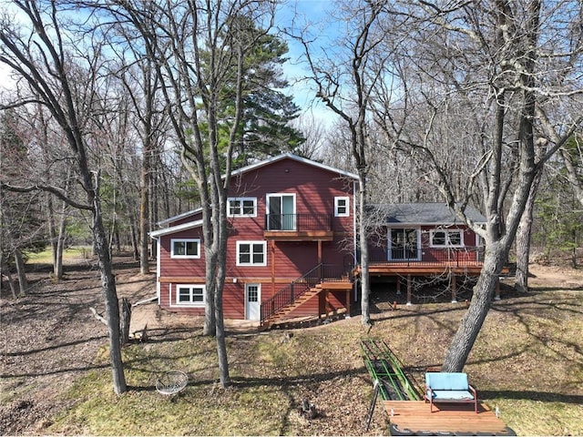 rear view of house featuring stairway and a deck