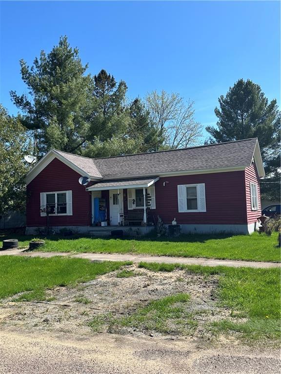 single story home featuring covered porch and a front lawn
