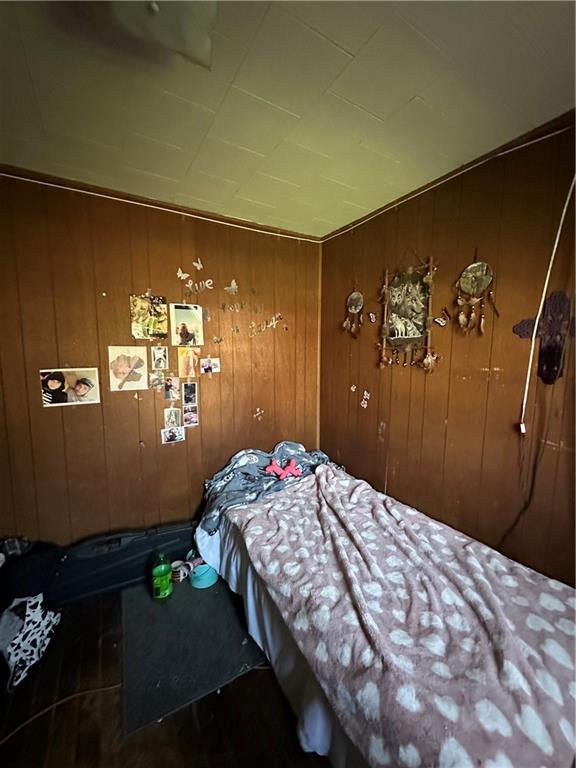 bedroom featuring wood walls