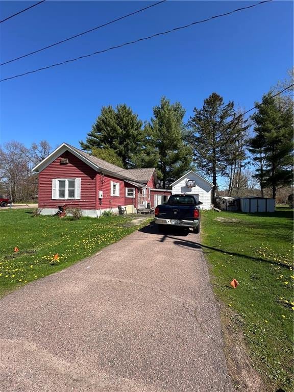 view of home's exterior featuring driveway and a lawn