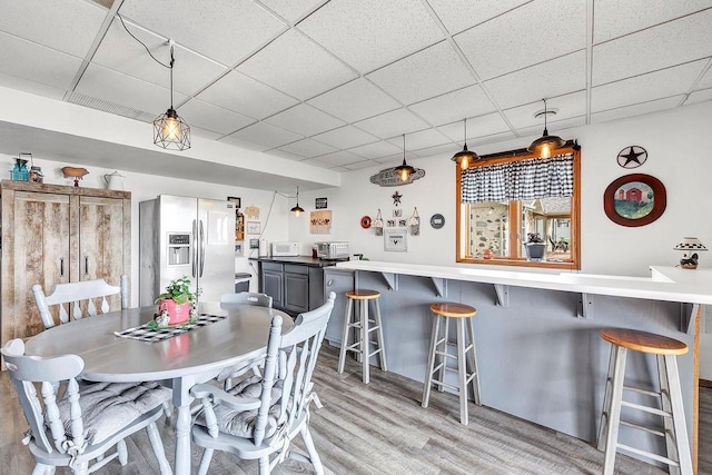 3280 County Rd S, Little Suamico, WI 54141 - dining room featuring light wood finished floors, a bar, and a paneled ceiling