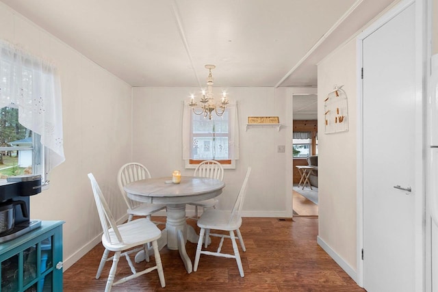 dining space featuring a chandelier, wood finished floors, and baseboards