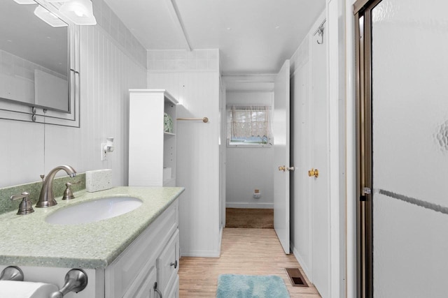 bathroom with vanity, visible vents, and wood finished floors