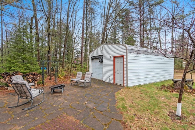 view of patio / terrace featuring an outdoor fire pit and an outdoor structure