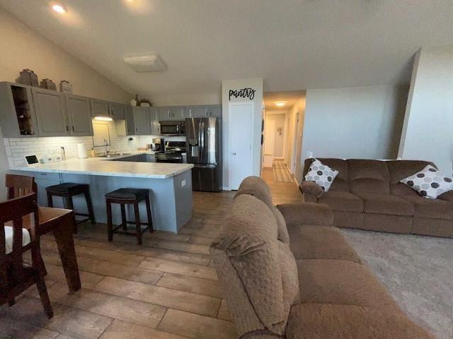 3403 Lever St Unit B, Eau Claire, WI 54701 - kitchen featuring a peninsula, a sink, gray cabinets, stainless steel microwave, and fridge with ice dispenser