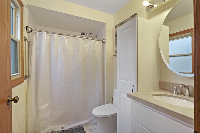 bathroom featuring toilet, vanity, and a shower with curtain