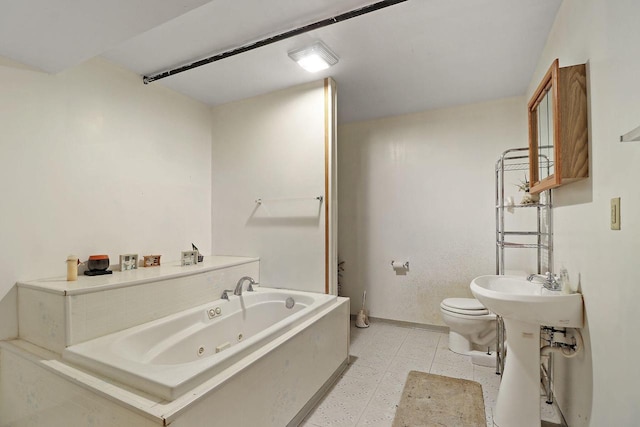 bathroom with tile patterned floors, a tub with jets, toilet, and baseboards