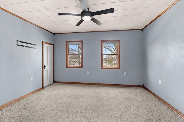 empty room with baseboards, ceiling fan, crown molding, and carpet floors