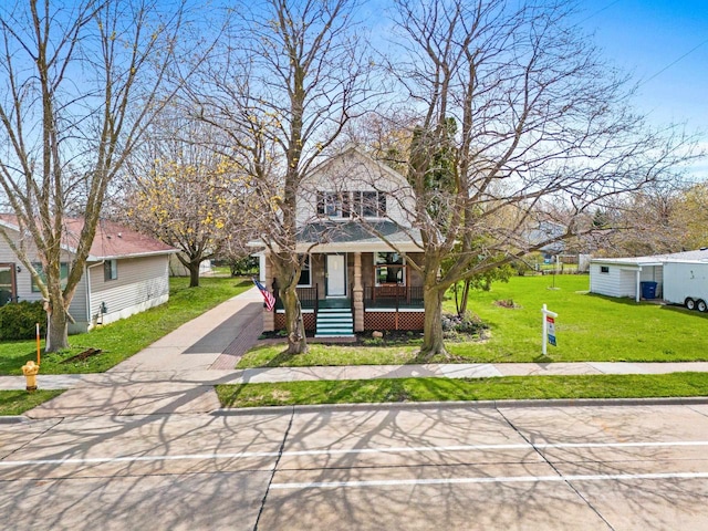 view of front of home with driveway, a porch, and a front lawn