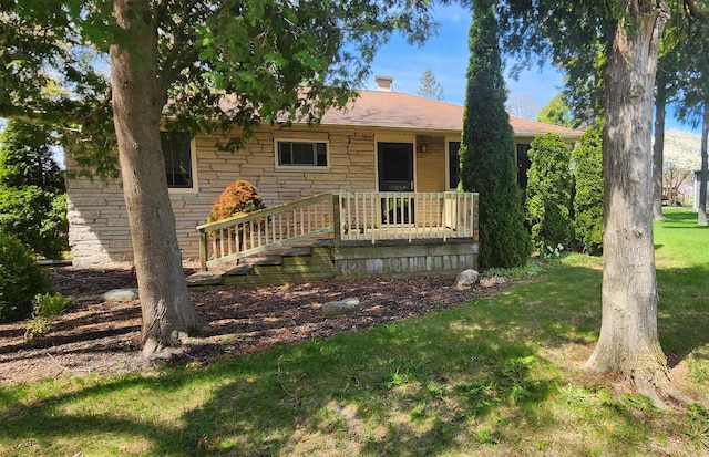 view of front of home featuring stone siding and a front yard