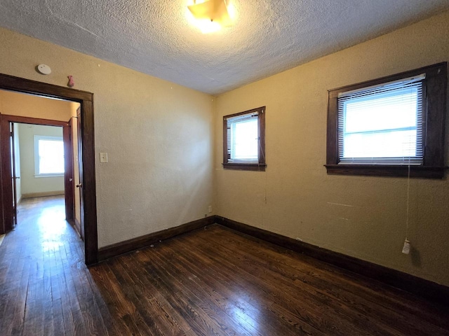 5535 N 40th St, Milwaukee, WI 53209 - unfurnished room featuring dark wood-style flooring, a textured ceiling, and a wealth of natural light