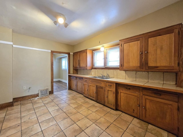 5535 N 40th St, Milwaukee, WI 53209 - kitchen with brown cabinets, tile countertops, and a sink