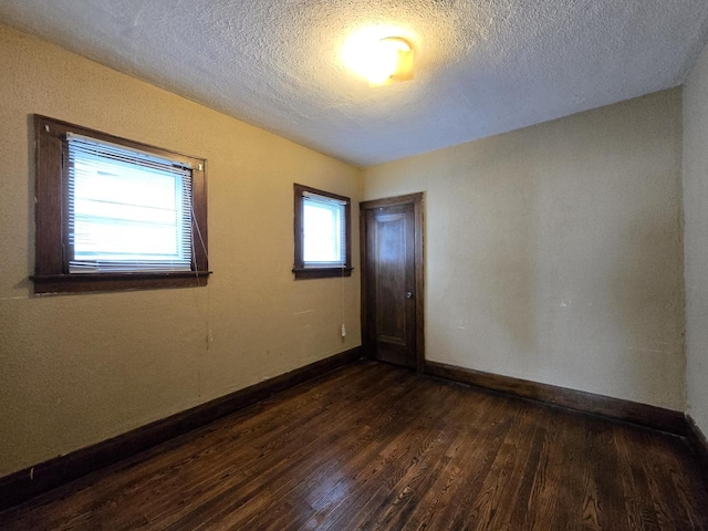 5535 N 40th St, Milwaukee, WI 53209 - unfurnished room featuring baseboards, dark wood finished floors, and a textured ceiling
