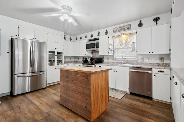 kitchen featuring a sink, stainless steel appliances, butcher block countertops, and white cabinets