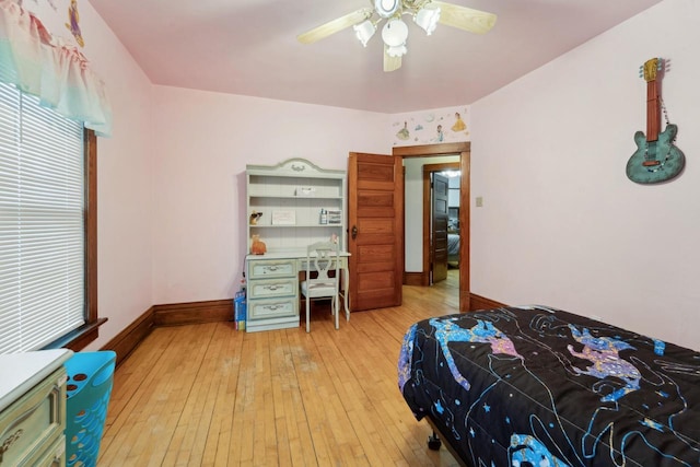 bedroom featuring a ceiling fan, light wood-style floors, and baseboards