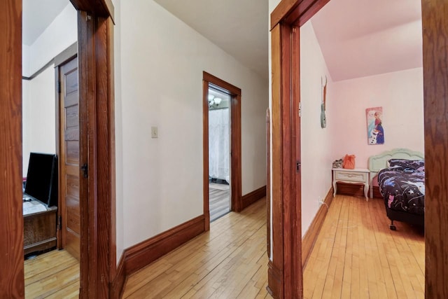 hallway featuring baseboards and light wood-type flooring