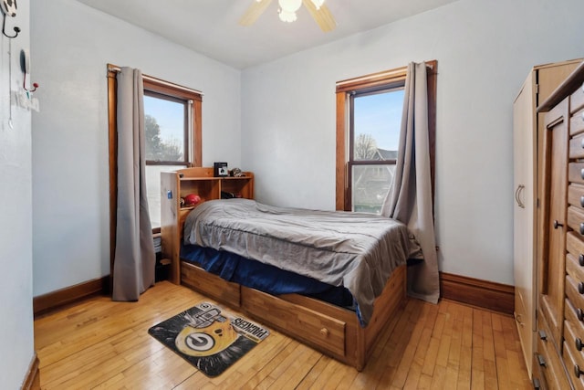 bedroom with baseboards, a ceiling fan, and wood-type flooring